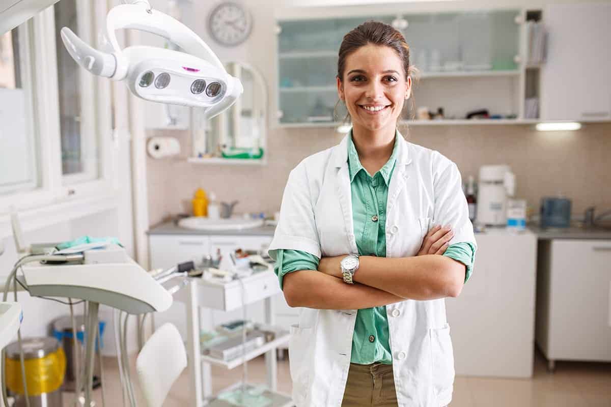 Dentist stands with arms crossed as a patient asks what fluoride is