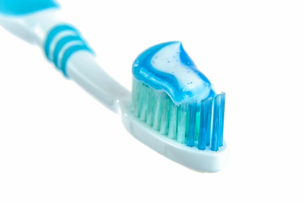 Close up of a toothbrush with toothpaste on it.
