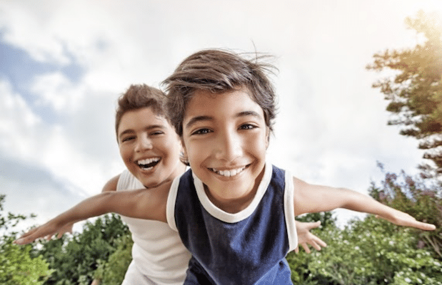two young boys smiling down at the camera