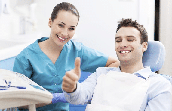an orthodontic patient giving a thumbs up while sitting on the orthodontic chair