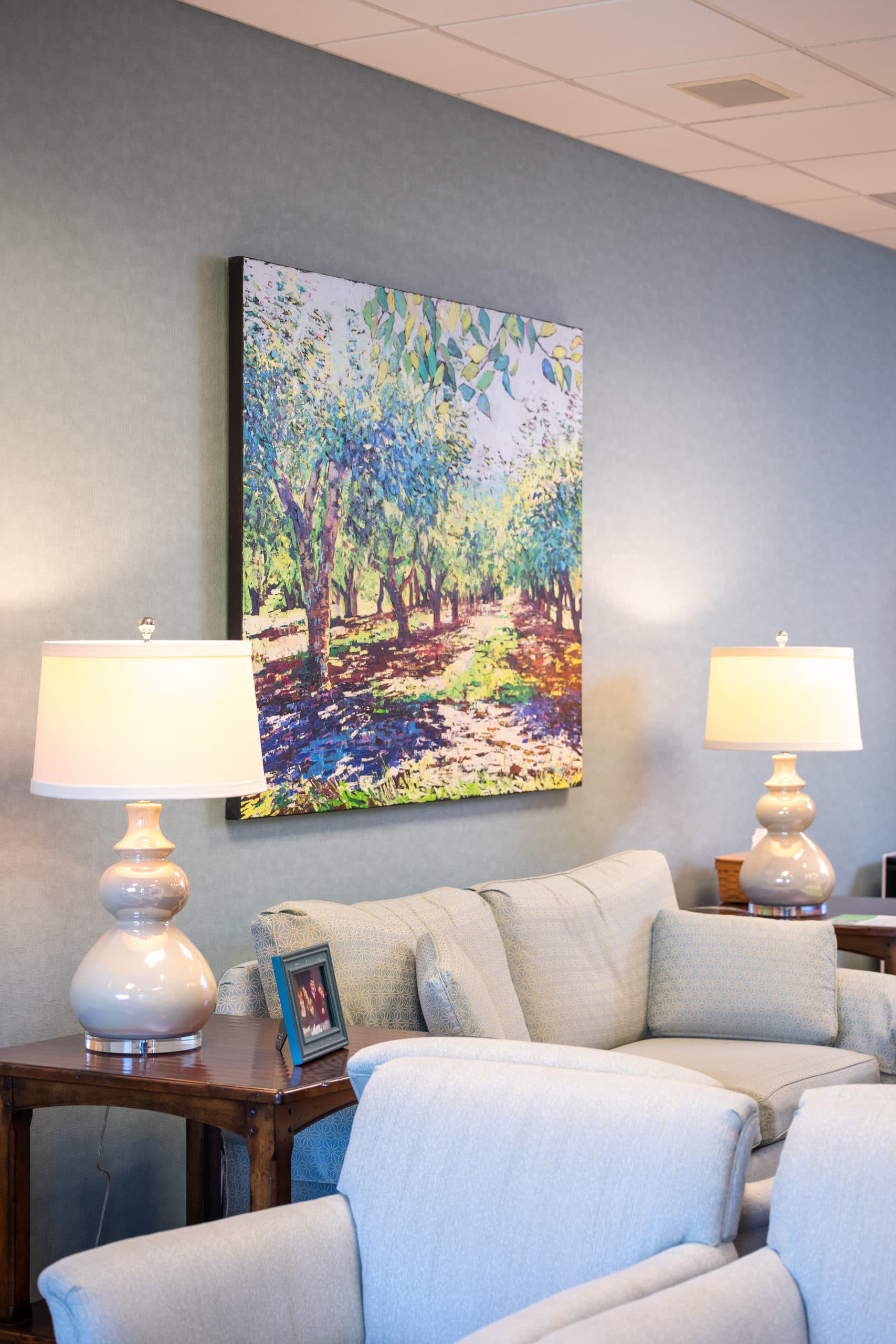 A picture of a couch and painting of trees in our waiting area.