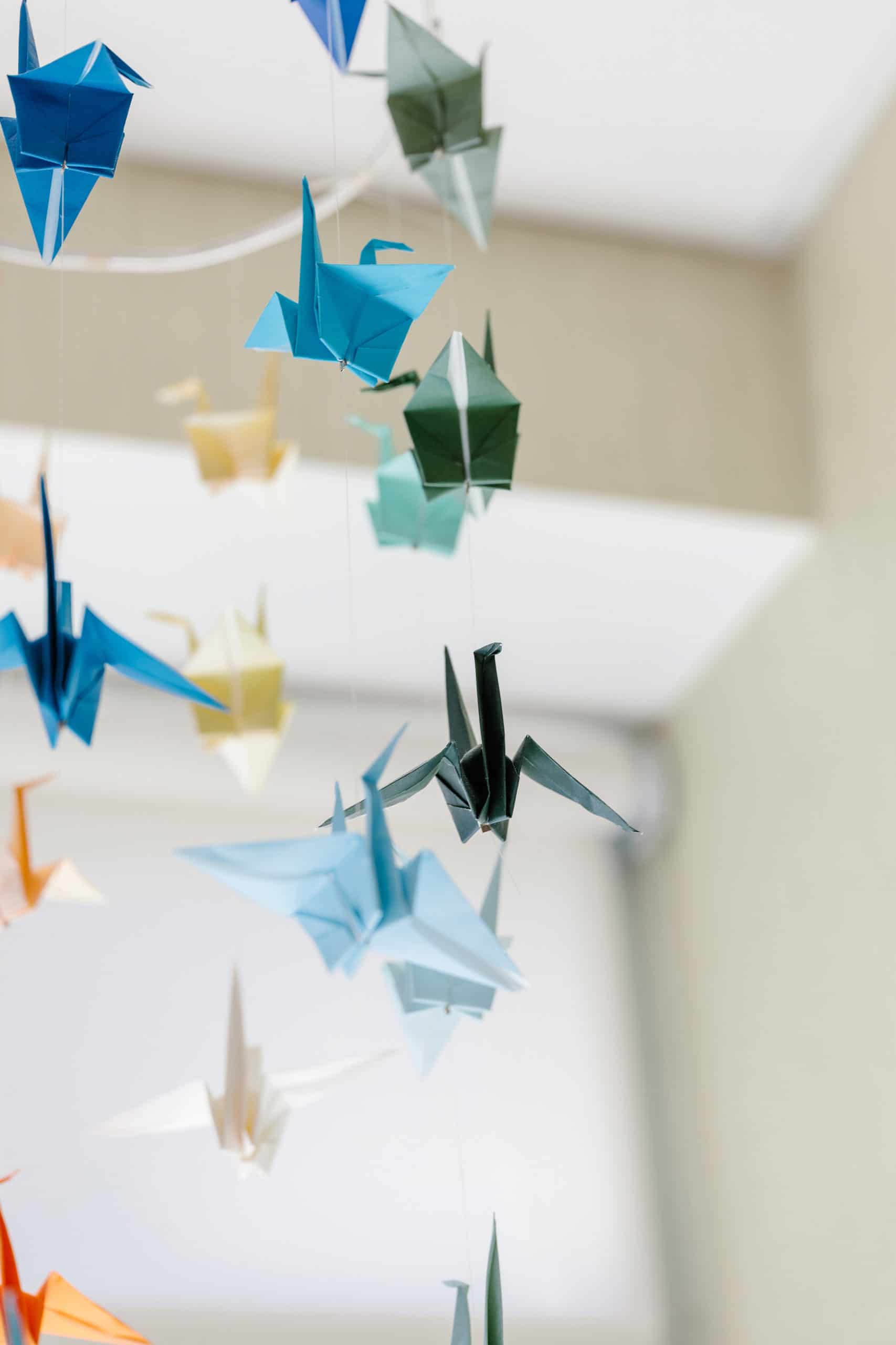 A mobile with paper cranes attached to it.