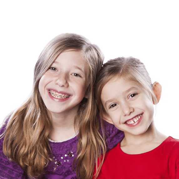 two little girls smiling, one has braces and the other does not