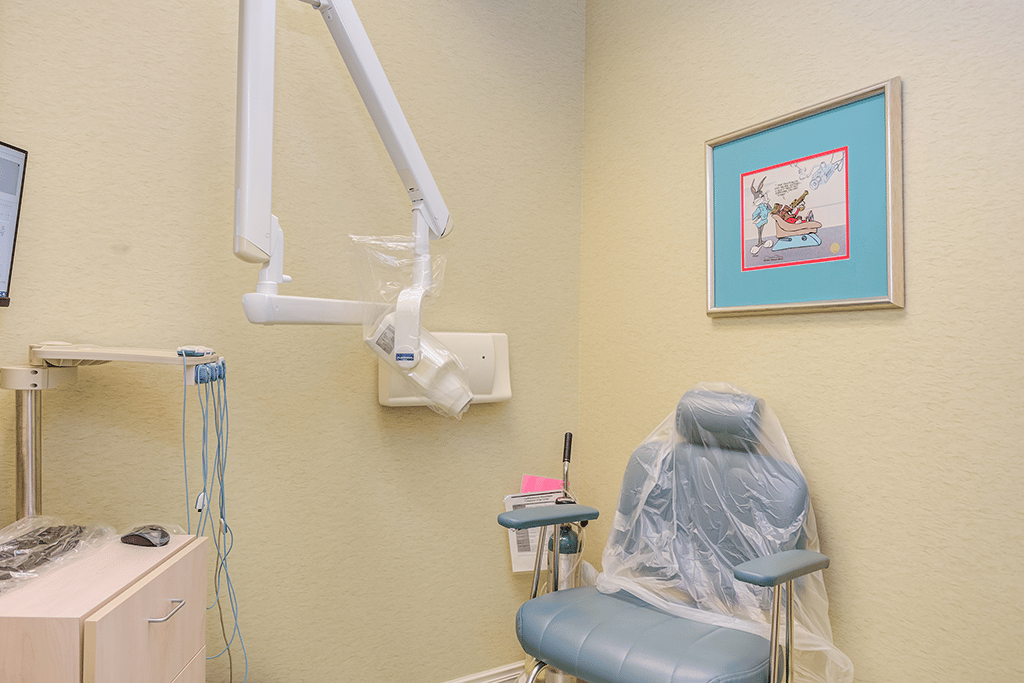 a orthodontic room with a chair and an x ray monitor