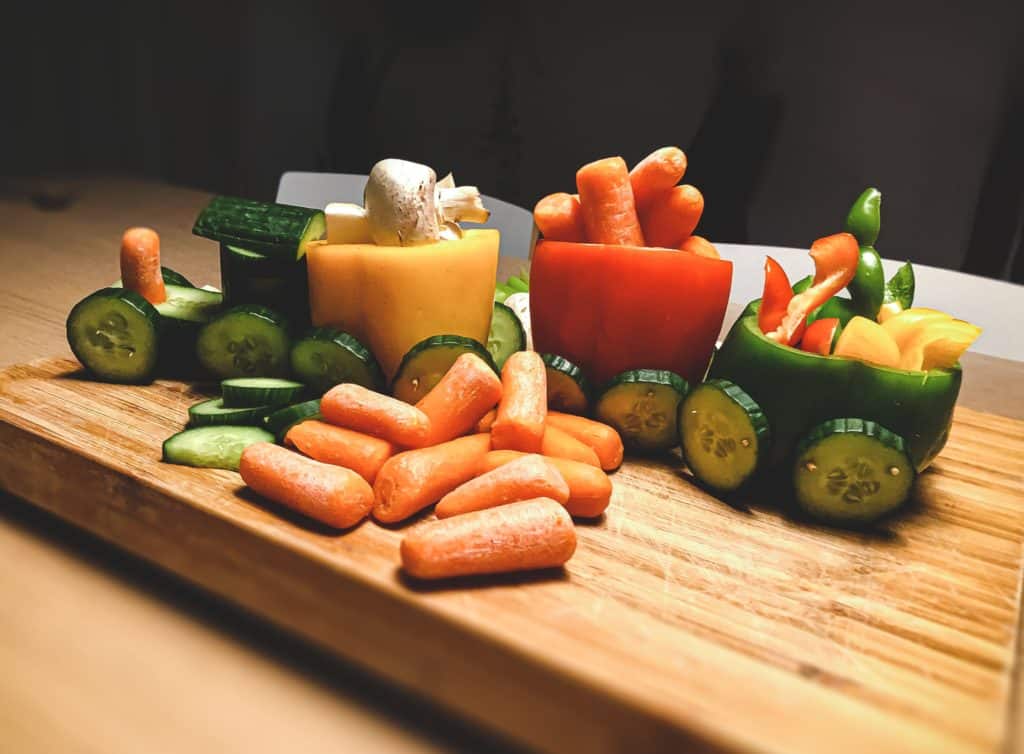 a wooden platter with lots of veggies on top of it