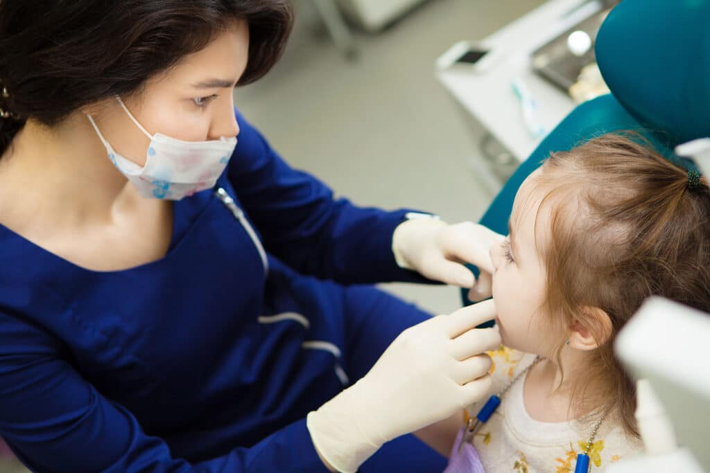 Dentist talks to child about children undergoing anesthesia