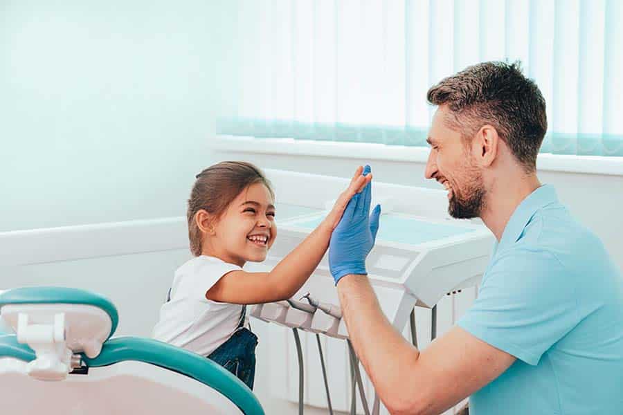 little girl giving a high five after her dental visit