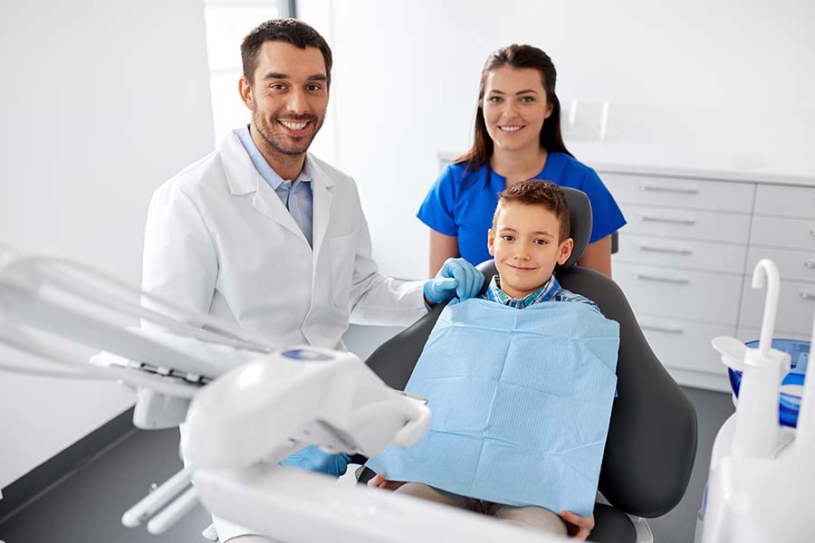little boy sitting in dentist chair after their parent looked at financial options