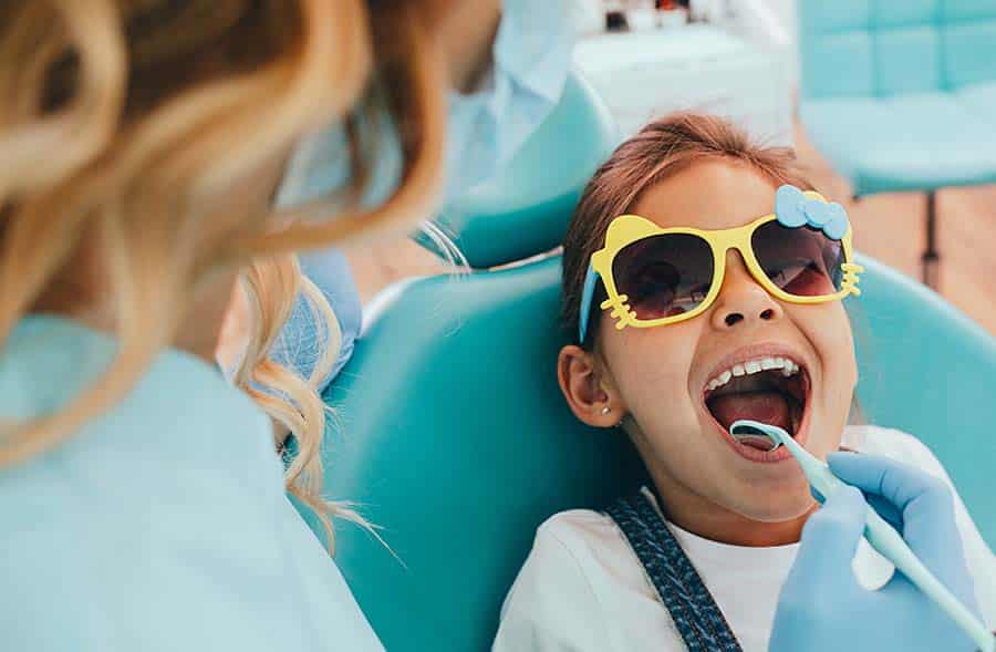 little girl in dentist chair after her parents discussed financial options