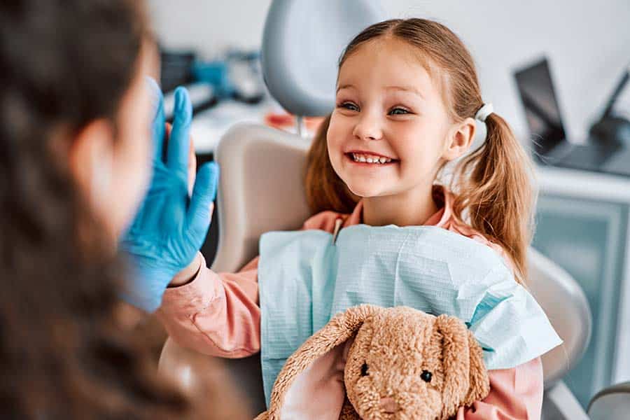 little girl giving high five after a successful trip to the dentist