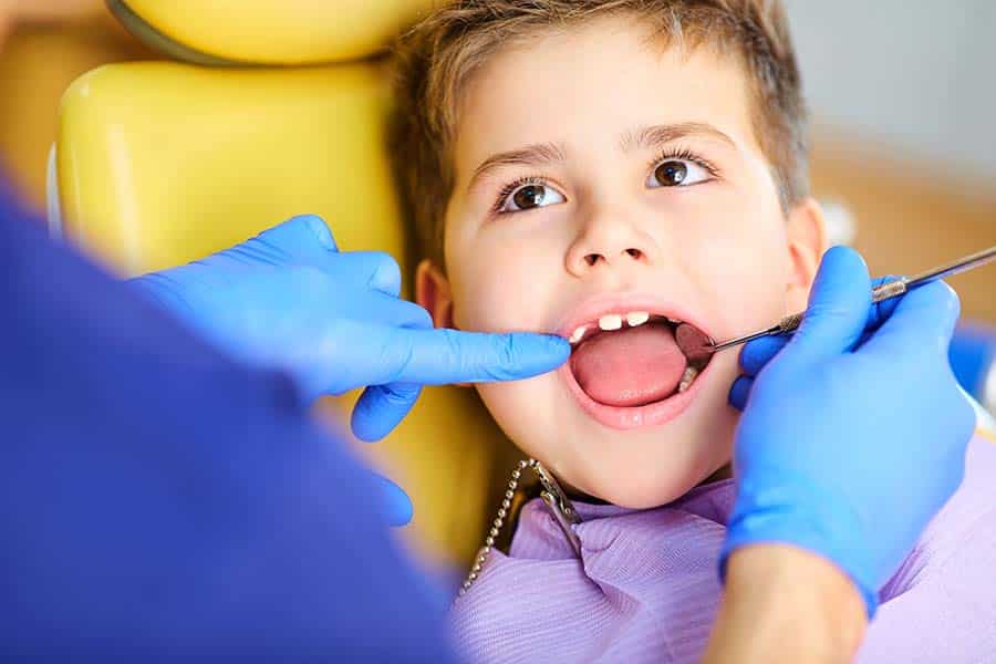 a little boy having his teeth check before receiving sedation dentistry
