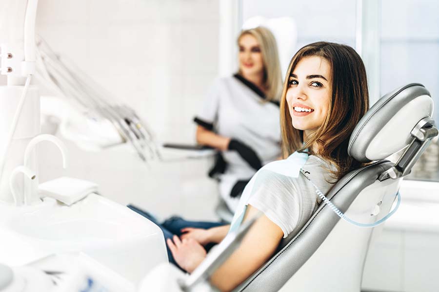 A woman sitting in a dentist chair waiting to receive treatment for her common tooth problems