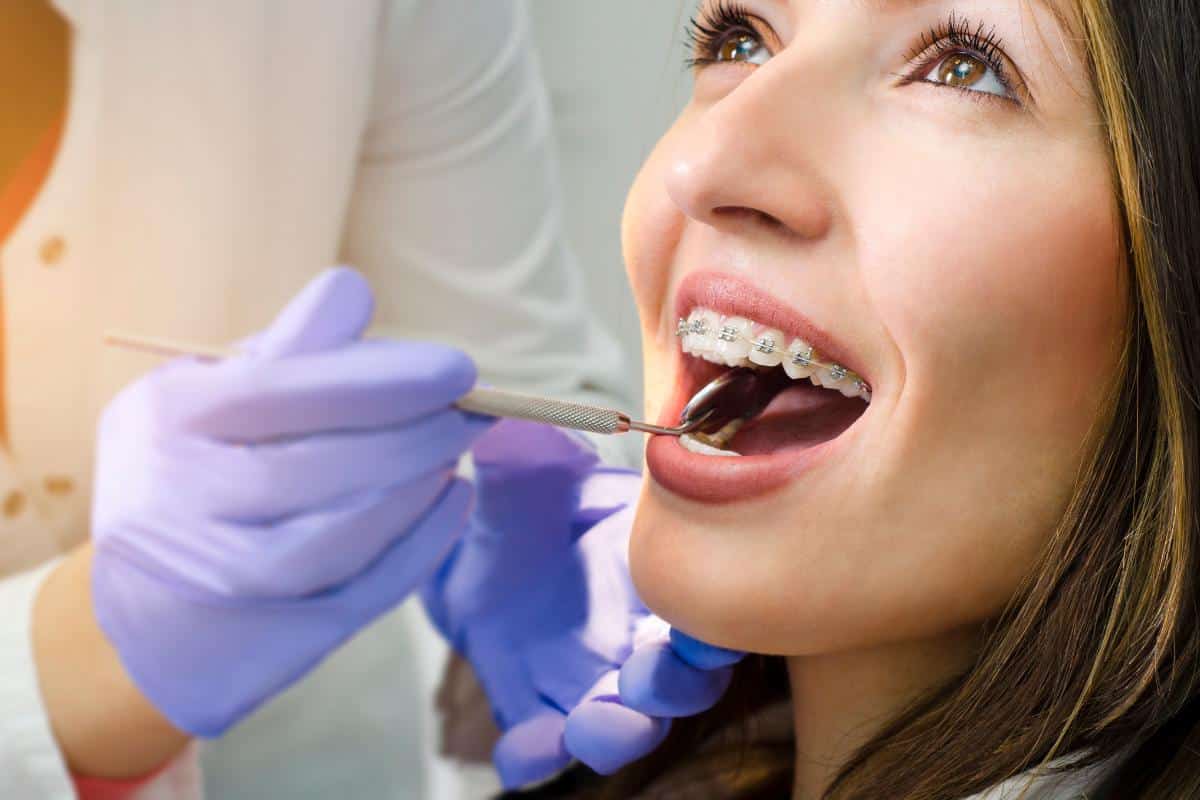 a woman has braces adjusted at the orthodontist