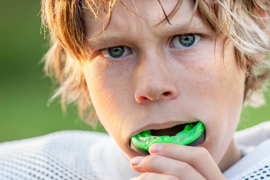 an athlete uses a custom sports mouth guard on the field