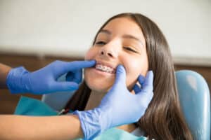 an orthodontist advises a patient about braces discomfort