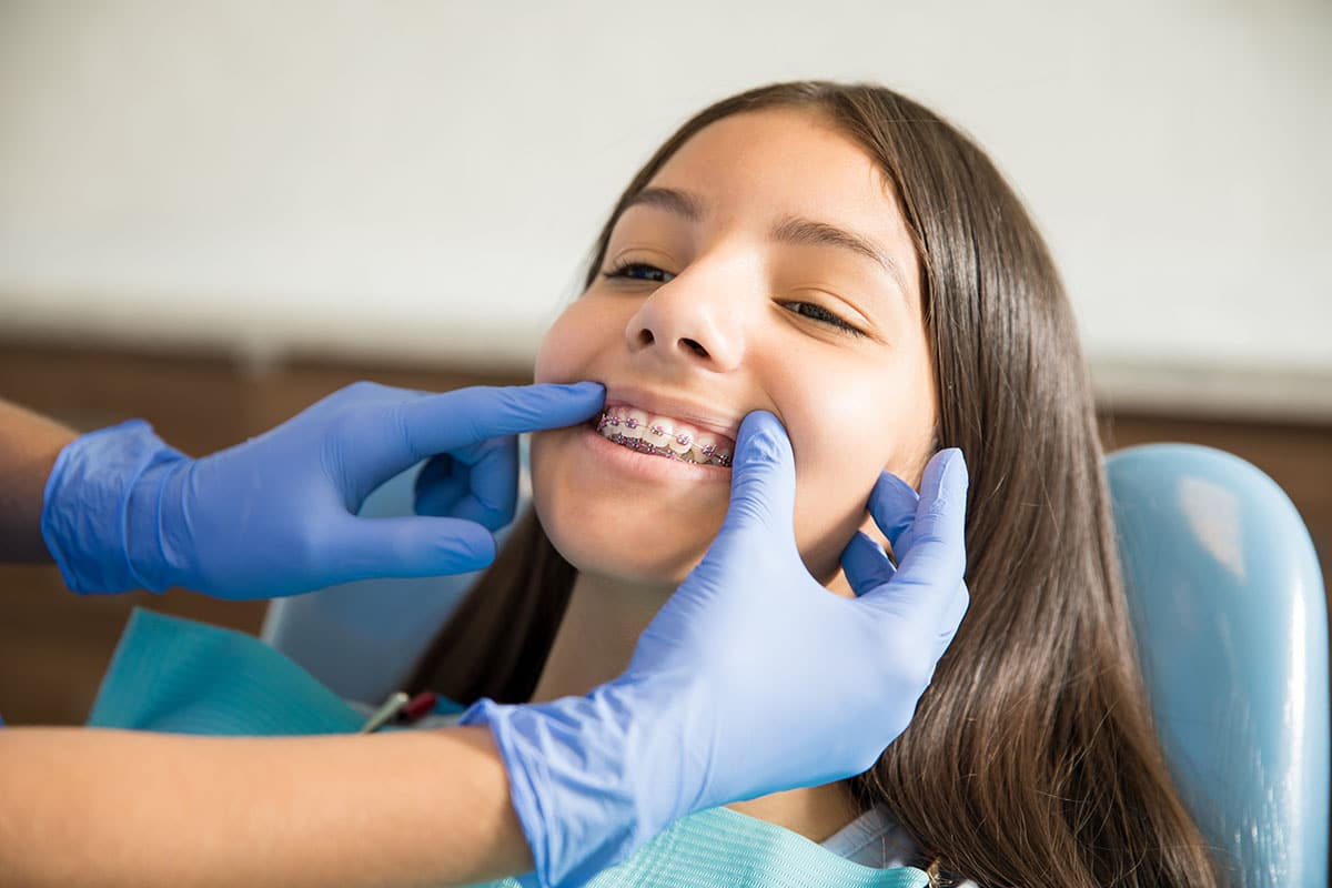 an orthodontist advises a patient about braces discomfort