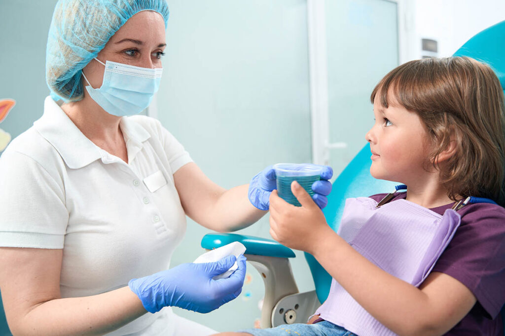 a child gets an oral rinse at the dentist