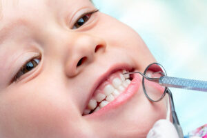 a child smiles to show no cavities at a dentist appointment