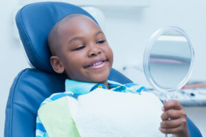 Young boy looking into mirror while in dentist's office