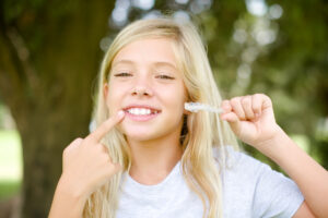 Young girl holding retainer