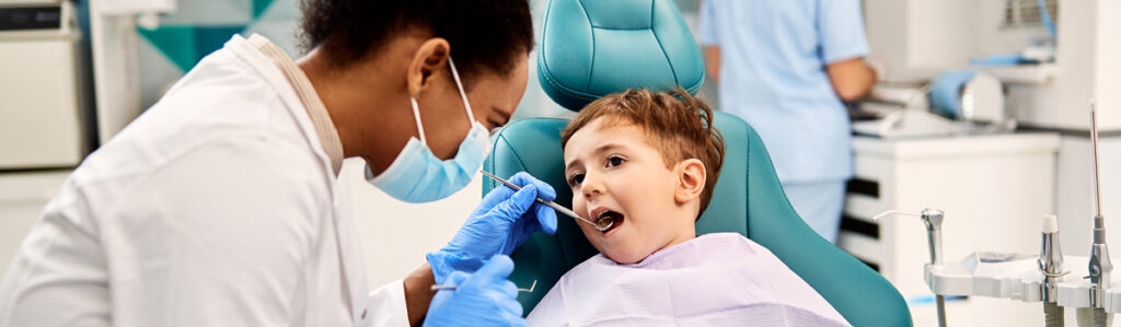 Dental hygienist cleaning boy's teeth